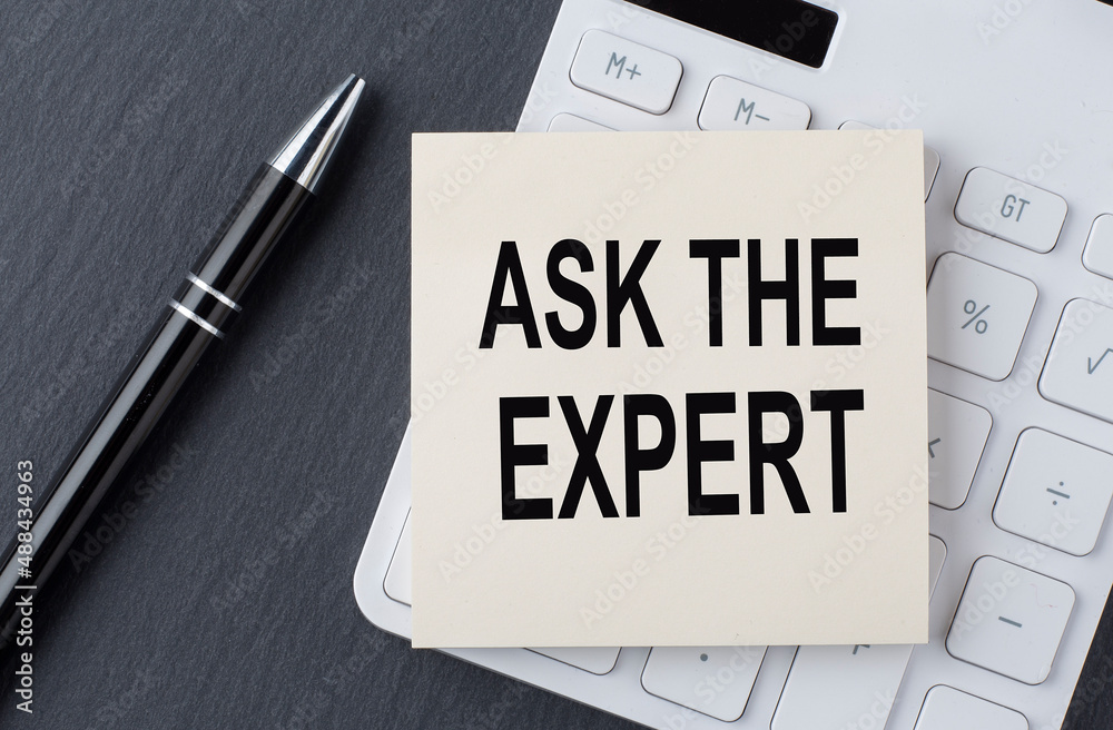 Text ASK THE EXPERT on the sticker on calculator, business concept Text ASK THE EXPERT on the sticker on calculator, business concept