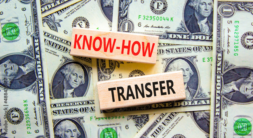 Know-how transfer symbol. Concept words Know-how transfer on wooden blocks on beautiful background from dollar bills, copy space. Business, innovation and know-how transfer concept.