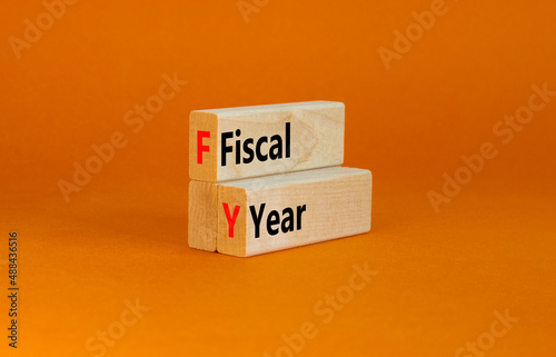 FY Fiscal year symbol. Concept words FY Fiscal year on wooden blocks on a beautiful orange table orange background. Business and FY fiscal year concept.