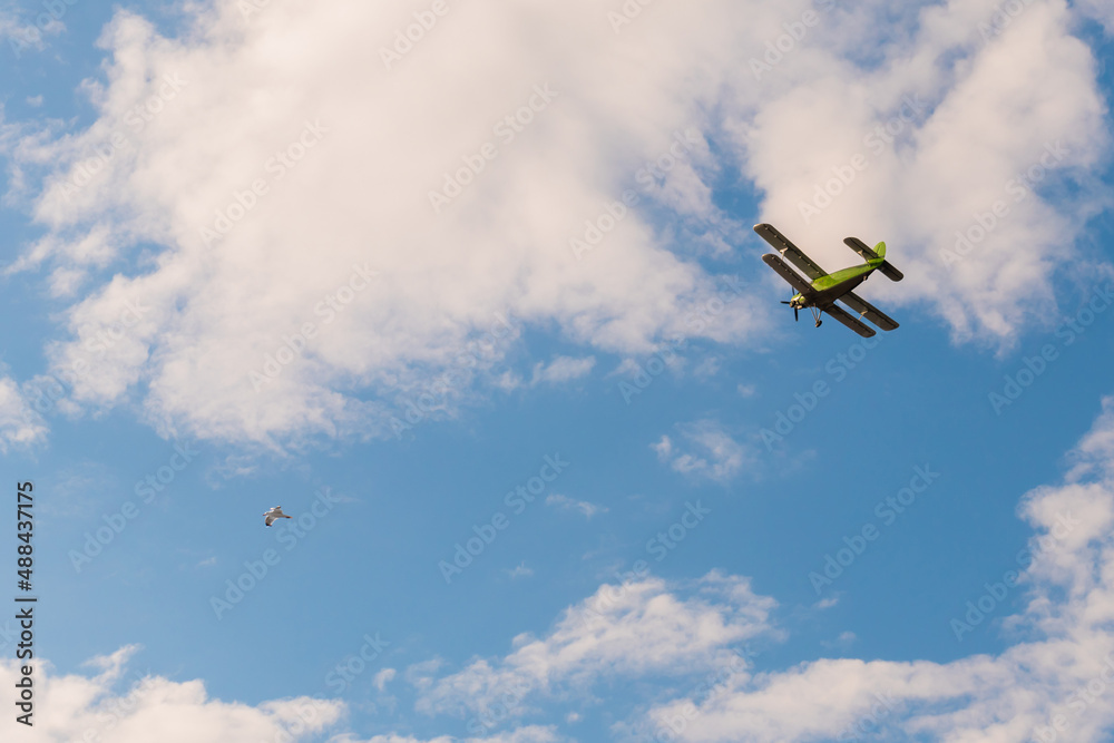 Green biplane, retro airplane flying in blue sky and doing stunts at Air Show. Performance, extreme, aerobatic, sport and aircraft concept Green biplane, retro airplane flying in blue sky and doing stunts at Air Show. Performance, extreme, aerobatic, sport and aircraft concept