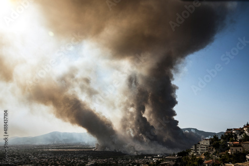 Athens, Greece, 03 August 2021: View of a major wild fire reached residential areas, at Varympompi suburb north of Athens. The thick smoke shows the phenomenon of pyrocumulus. 