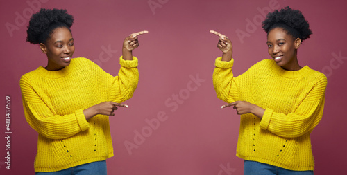 Happy young african american female twins sisters pointing aside on copy space for online store advertising photo