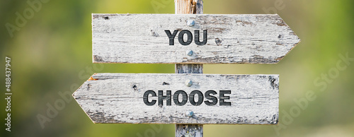 Fotografi opposite signs on wooden signpost with the text quote you choose engraved