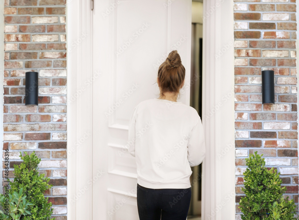 Beautiful woman opening the door of her home. Beautiful woman opening the door of her home.
