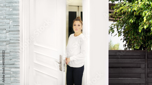 Beautiful woman opening the door of her home.