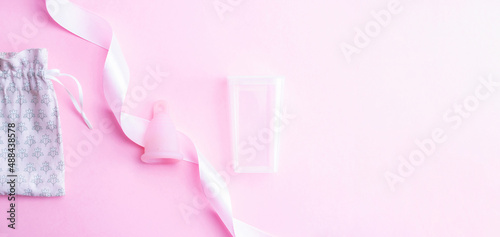 Menstrual cycle sanitary cup. Pink ribbon with menstrual cup. Menstruation feminine period. Sanitary hygiene banner. Use menstrual cup inside vagina. © Maksym