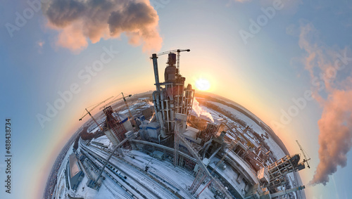 Fotografia Aerial view from high altitude of little planet earth with cement factory tower with high concrete plant structure at industrial production area at sunset