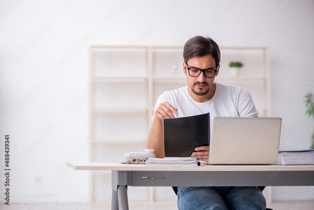 Young male employee freelancer sitting in the office