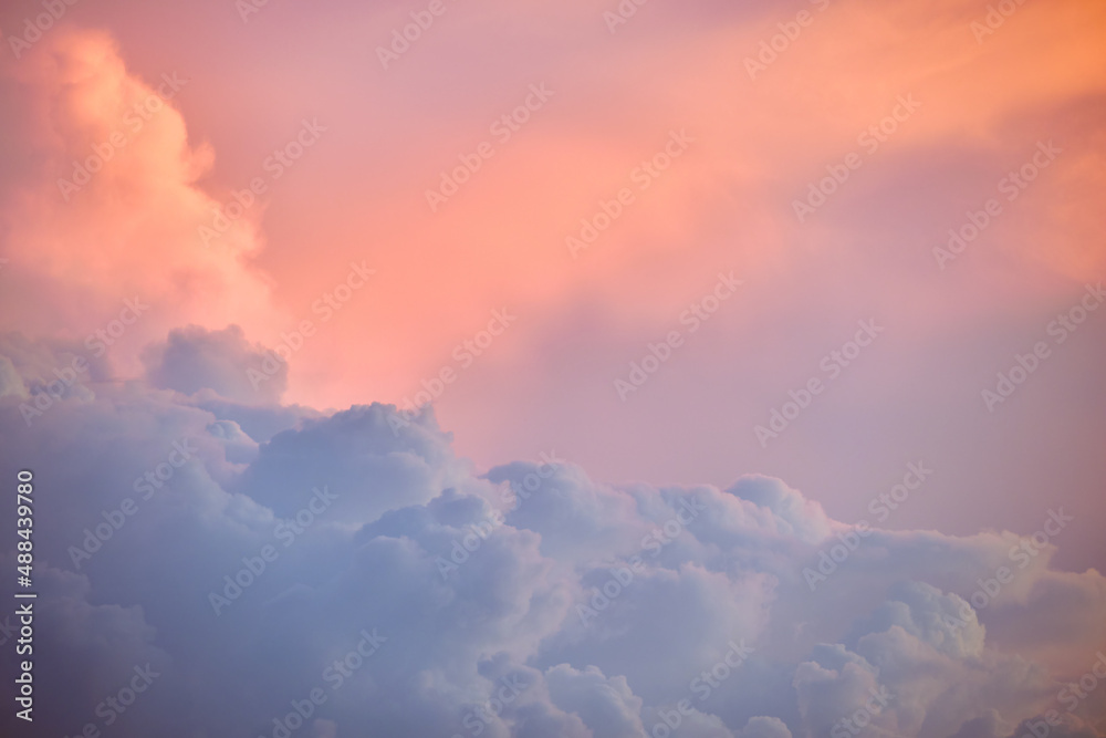 Colorful evening landscape with soft pastel coloured clouds on watercolor tinted sunset sky. Abstract nature background