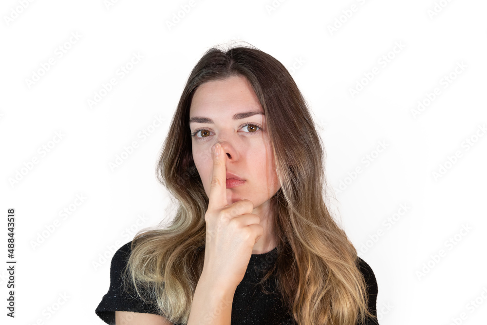 A young woman wants to correct shape of her nose. Plastic surgery and aesthetic medicine. Rhinoplasty. Attractive young woman on white background. Loving yourself as you are. A young woman wants to correct shape of her nose. Plastic surgery and aesthetic medicine. Rhinoplasty. Attractive young woman on white background. Loving yourself as you are.