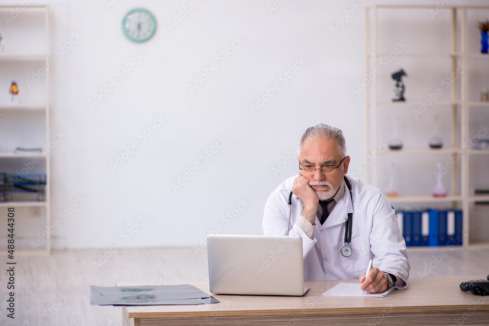 Old male doctor working at the hospital Old male doctor working at the hospital