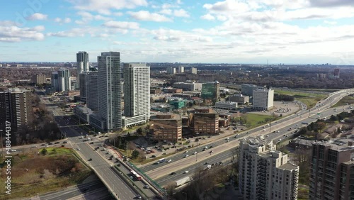 Don Valley Parkway going towards condos with traffic  underneath blue skies and clouds photo