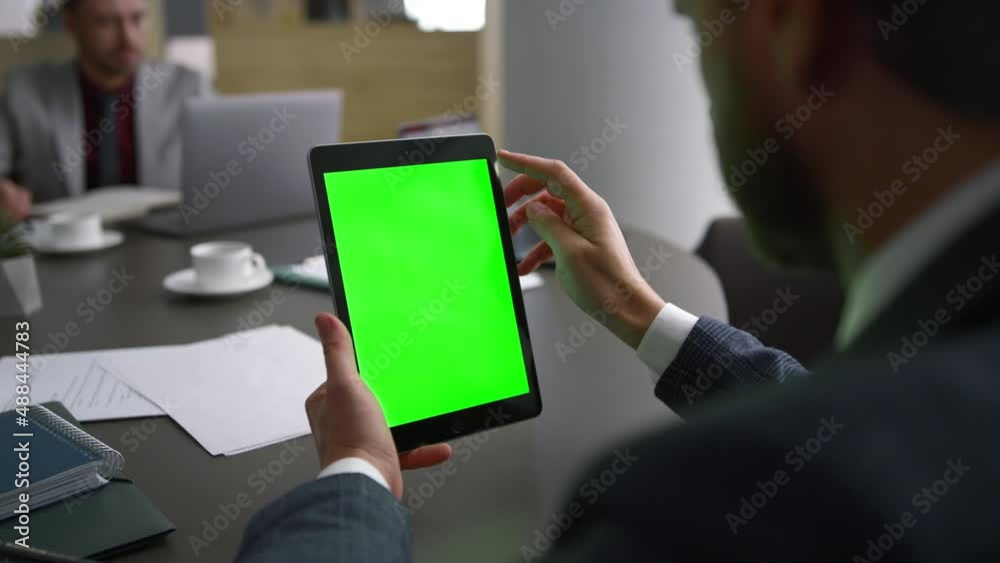 Financial worker browsing tablet green screen searching web in business centre.