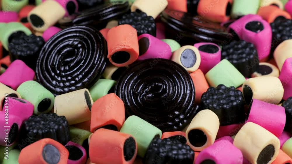 Macro view with rotation of licorice gummy candies. Colorful chewy