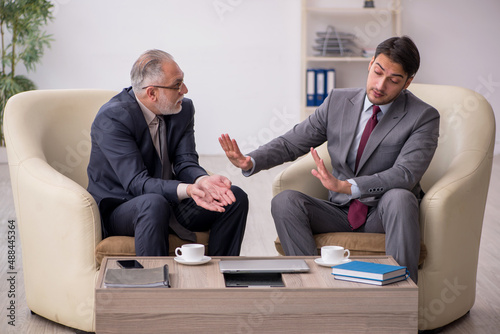 Two businessmen discussing project at workplace