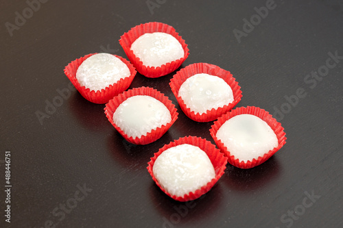 6 pieces of Japanese Style Red Bean Mochi in paper cups on a dark table
