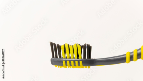 Oral hygiene. Black and yellow toothbrush on a white background.