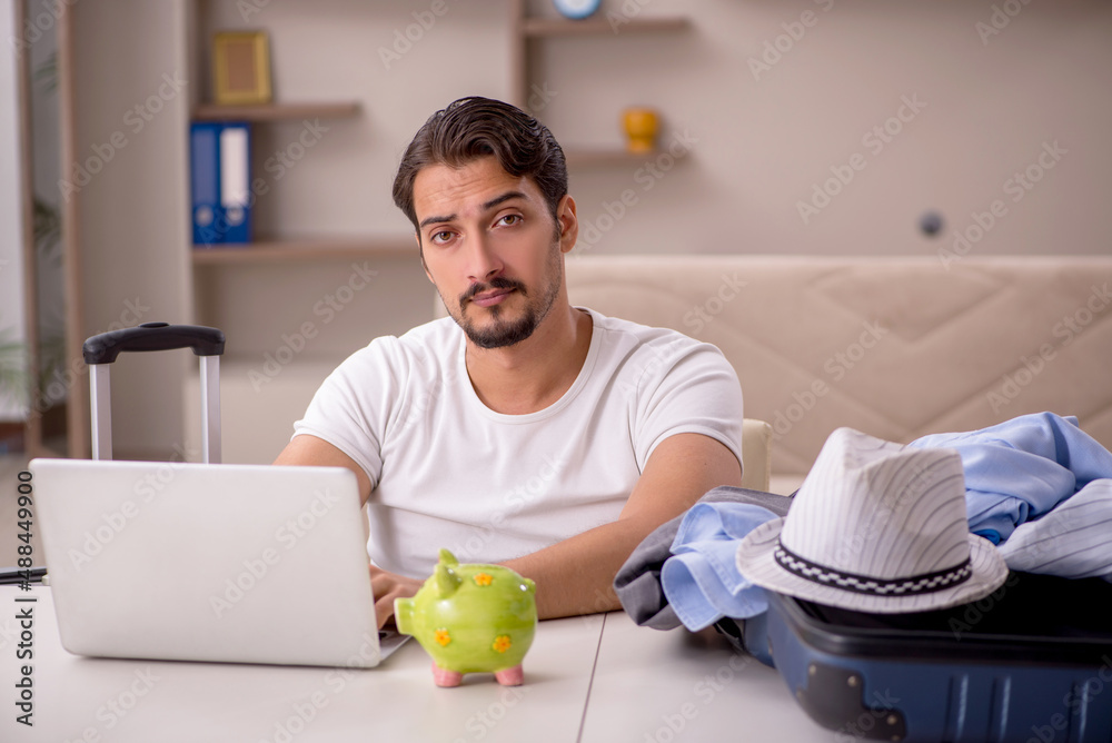 Fototapeta premium Young man preparing for trip at home