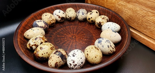 Fresh quail eggs close up. Quail eggs in a clay bowl. Easter eggs background.
