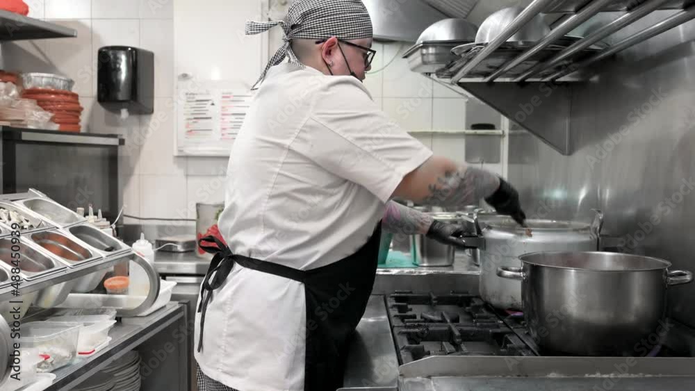 Side view of female chef working in commercial kitchen. High quality 4k footage Side view of female chef working in commercial kitchen. High quality 4k footage