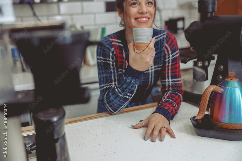 Woman barista standing behind the bar counter with cup Woman barista standing behind the bar counter with cup