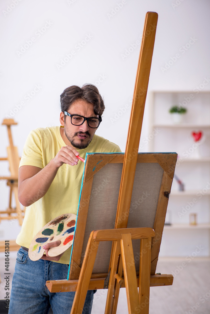 Young man enjoying painting at home Young man enjoying painting at home
