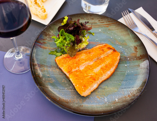 Delicious fried salmon fillet served with fresh greens salad. Healthy food concept.. photo