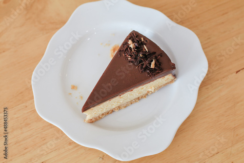 Homemade chocolate cake in white plate on wooden table. Selective focus. Copy space for your text.