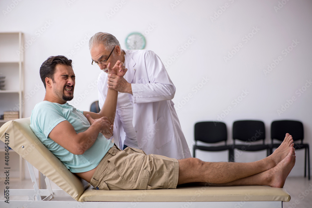 Obraz premium Young male patient visiting old male doctor