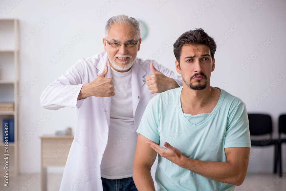 Young male patient visiting old male doctor Young male patient visiting old male doctor