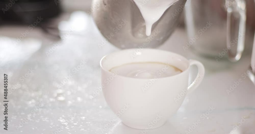 Pour the frothed milk on the espresso. Soft milk froth is poured on the surface of the coffee in the cup. Pour the frothed milk on the espresso. Soft milk froth is poured on the surface of the coffee in the cup.