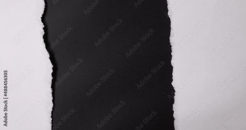 A paper is torn from the bottom up over a black background.