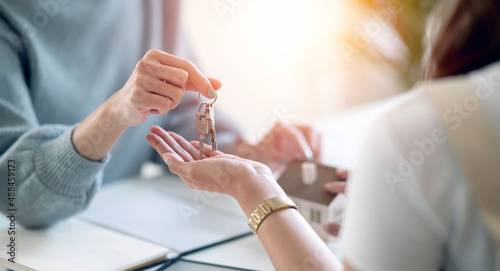 Female realestate agent giving house key to her customer  property  realestate concept.