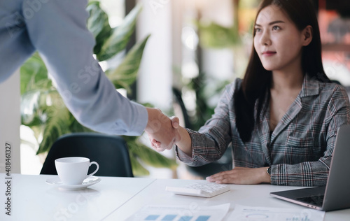 Business people handshake for teamwork of business merger and acquisition, successful negotiate, two asian business people shake hand with partner to celebration partnership and business deal concept.