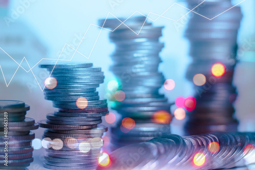 Double exposure of rows of coins for finance and business concept on city and bokeh of light background and financial status graph demonstrates business growth.