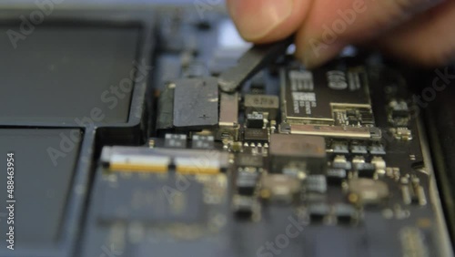 Technician repairs a defective laptop.