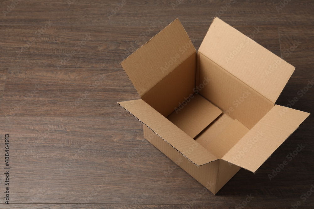 Empty open cardboard box on wooden table. Space for text Empty open cardboard box on wooden table. Space for text