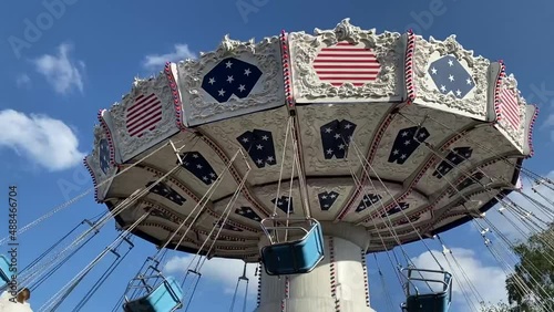 carousel turns in an amusement park, good weather, blue sky.