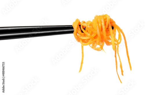 Chopsticks with delicious Korean carrot salad on white background photo