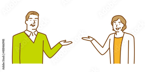片手を挙げて何かを案内する年配の男性と女性