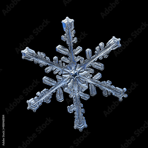 Snowflake isolated on black background. Macro photo of real snow crystal: elegant stellar dendrite with hexagonal symmetry, glossy 3D surface, complex inner details and six flat, fragile arms.