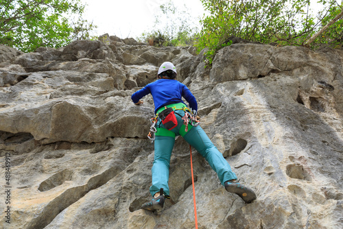 Fotografering Female rock climber on cliff