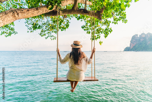 Traveler woman relaxing on swing above Andaman sea Railay beach Krabi, Leisure tourist travel Phuket Thailand summer holiday vacation trip, Beautiful destinations place Asia, Happy dream concept photo