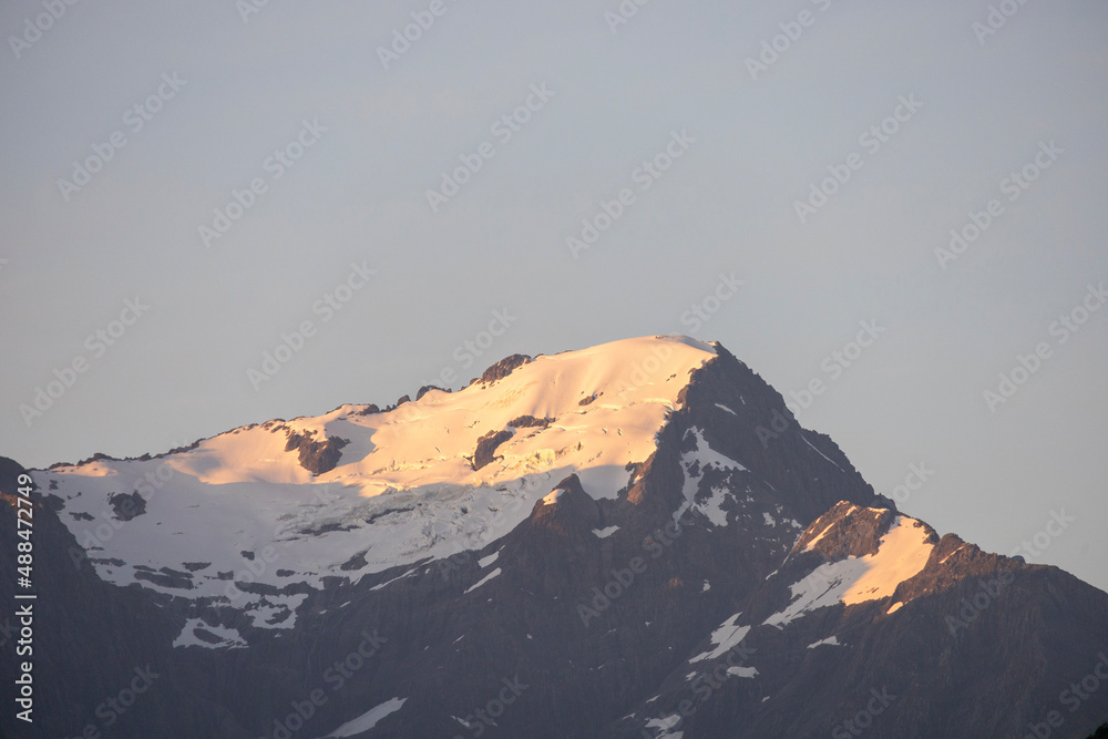first light on snow covered mountains