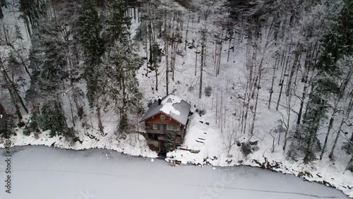 A lonely cabin sitting next to a frozen lake in the Bavarian forest photo