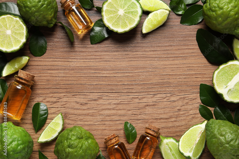 Frame of glass bottles with bergamot essential oil and fresh fruits on wooden table, flat lay. Space for text Frame of glass bottles with bergamot essential oil and fresh fruits on wooden table, flat lay. Space for text
