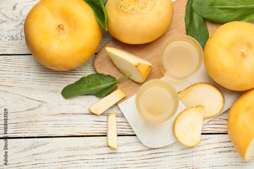 Freshly made turnip juice on white wooden table, flat lay