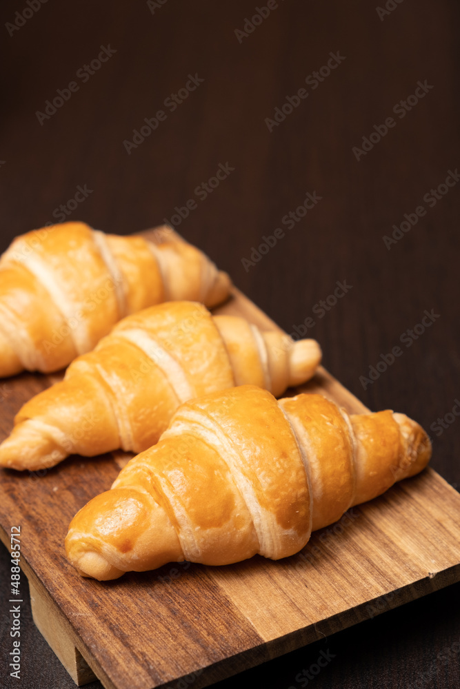 Fresh croissants on a wooden board. selective focus .bakery with copy space.