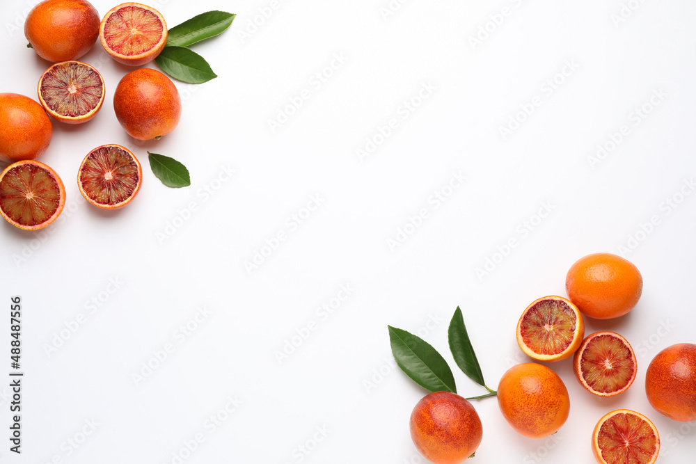 Many ripe sicilian oranges and leaves on white background, flat lay. Space for text - obrazy, fototapety, plakaty 