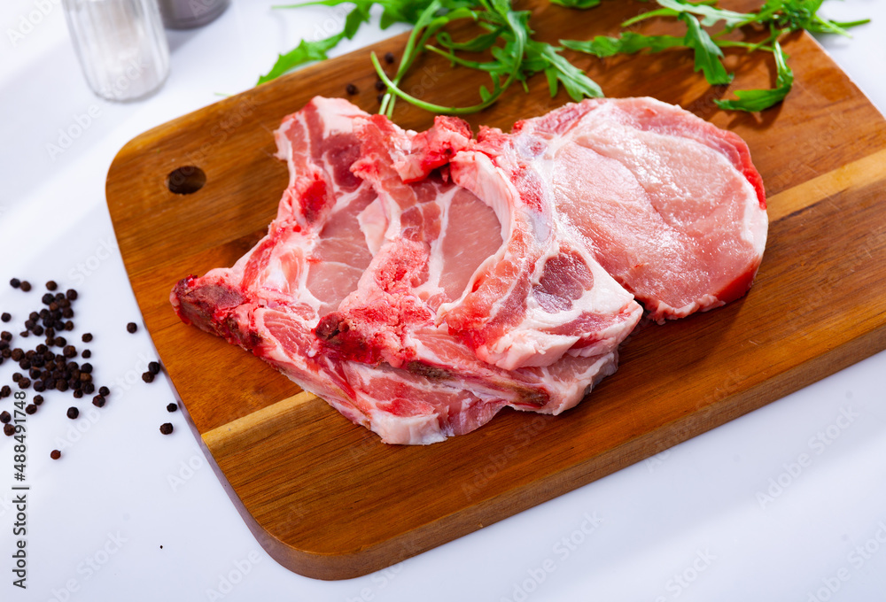 Closeup of fresh cutting loin chops from pork meat on a table at a kitchen